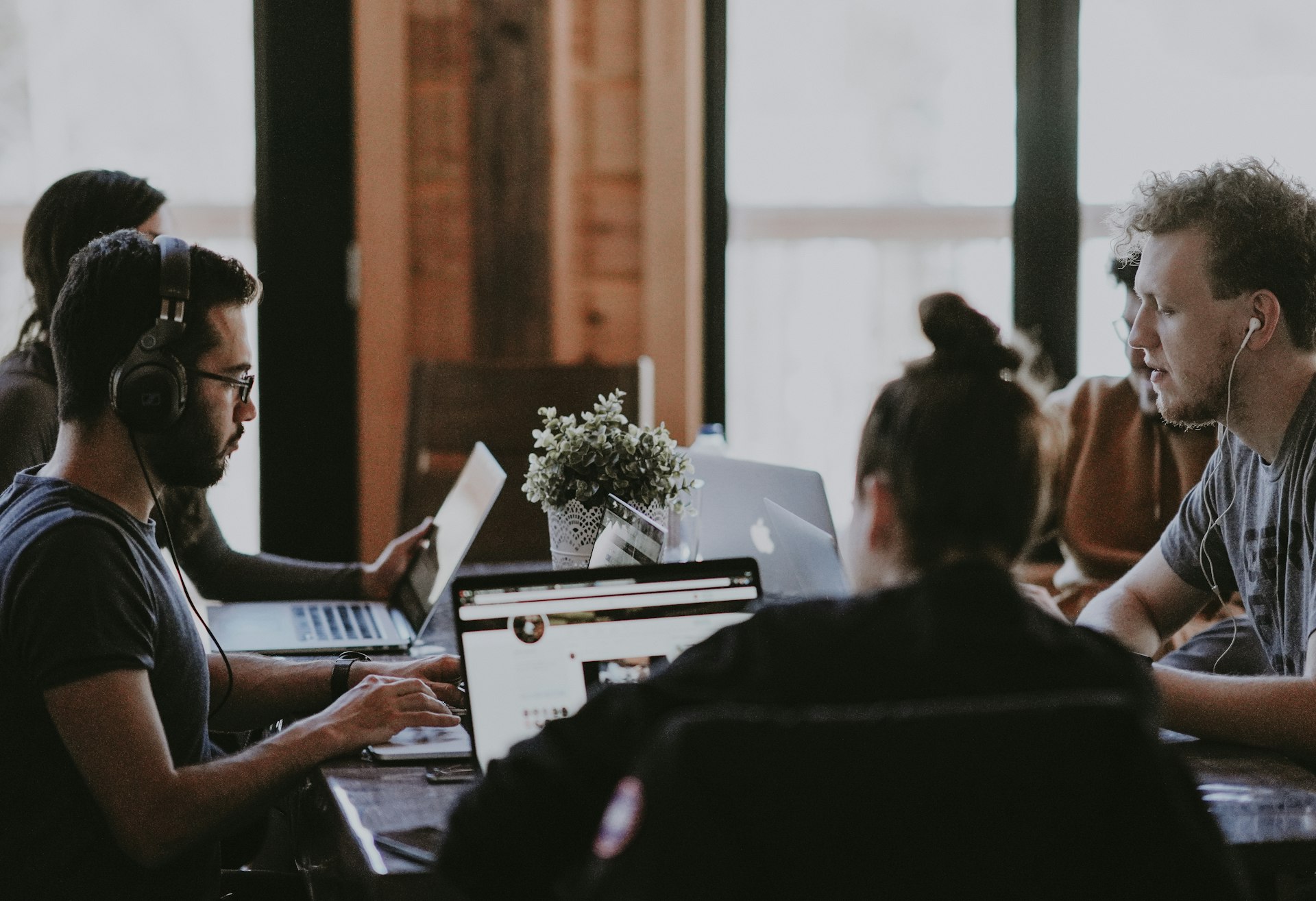 Team productivity selective focus photography of people sits in front of table inside room
